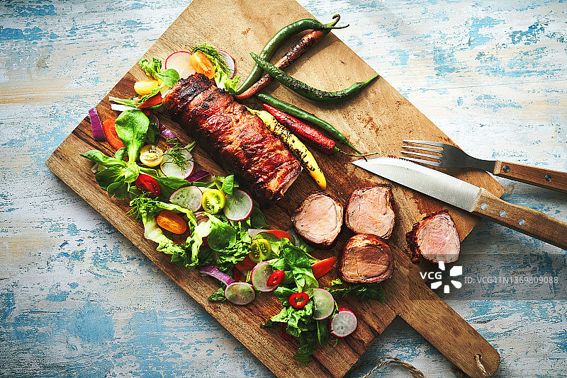培根烤猪里脊配蔬菜沙拉图片素材
