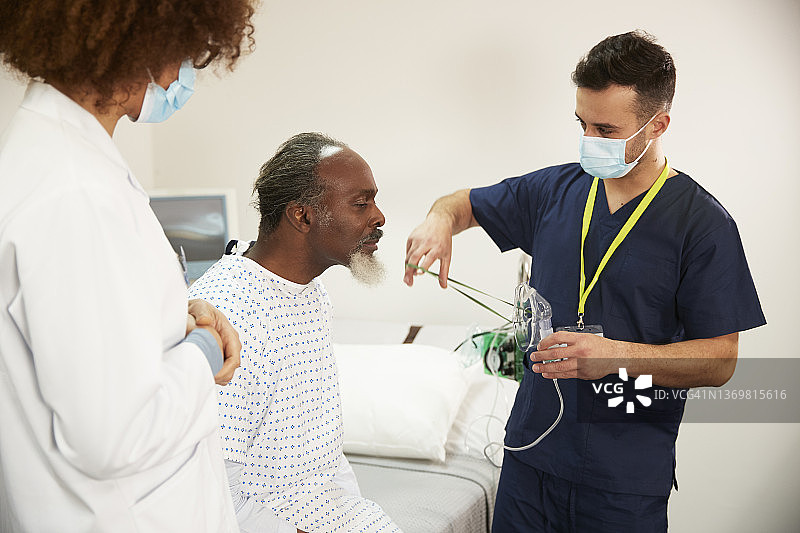 护士在医院帮助戴氧气面罩的病人图片素材