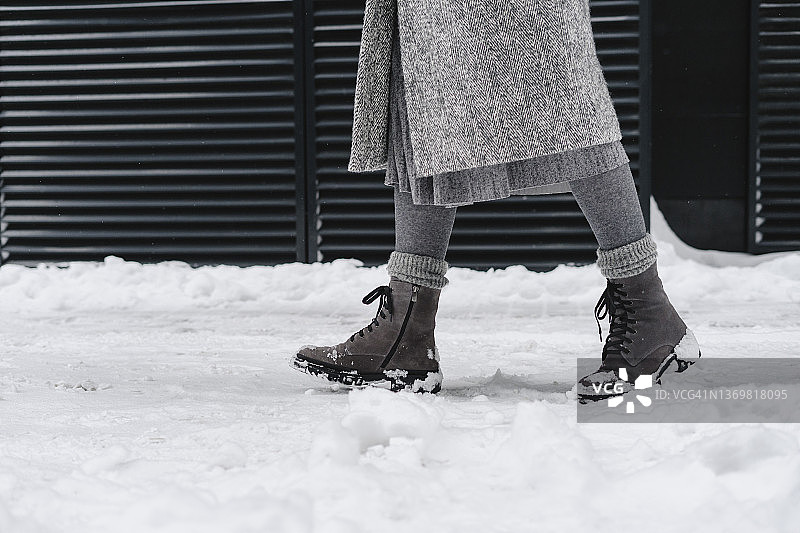 穿着雪地靴在人行道上行走的女人图片素材