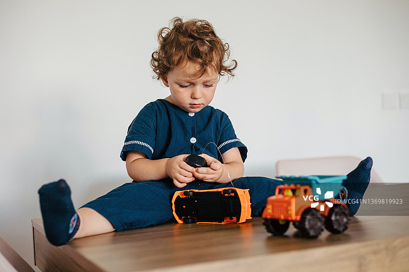 可爱小男孩在家玩玩具车图片素材