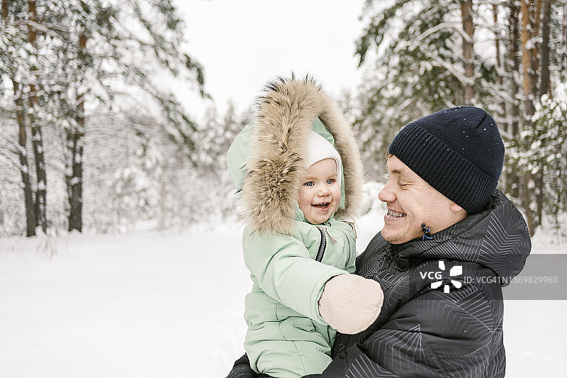 冬天父亲抱着穿派克服的女儿图片素材