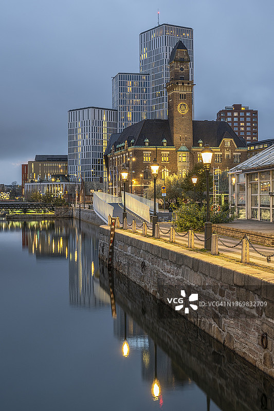 瑞典斯科讷省马尔默市运河黄昏景色，背景为世界海事大学和酒店图片素材