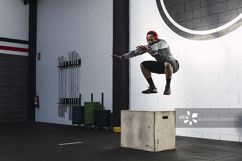 在健身房练习箱式深蹲的运动员图片素材