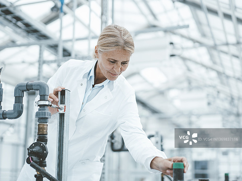 农艺师在实验室调整管道旋钮图片素材