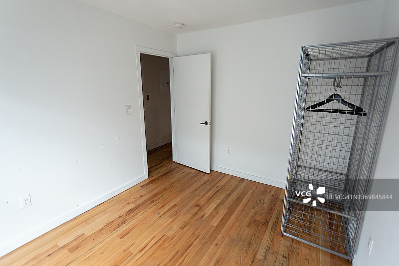 带金属丝衣柜和衣架的空房间图片素材