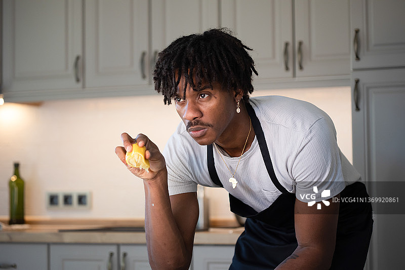 男人在厨房手拿柠檬的特写图片素材