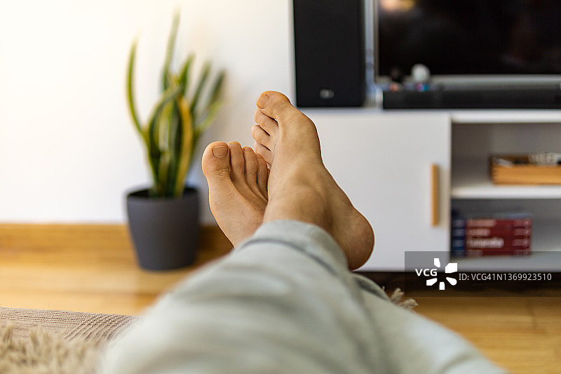 在家放松，赤脚躺在沙发上的男人双腿图片素材