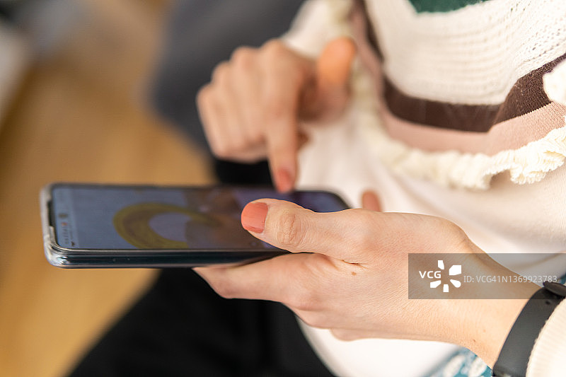 在家用智能手机打字的沙发上的女人图片素材