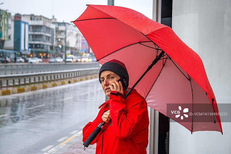 雨天，女子在公交车站等车图片素材