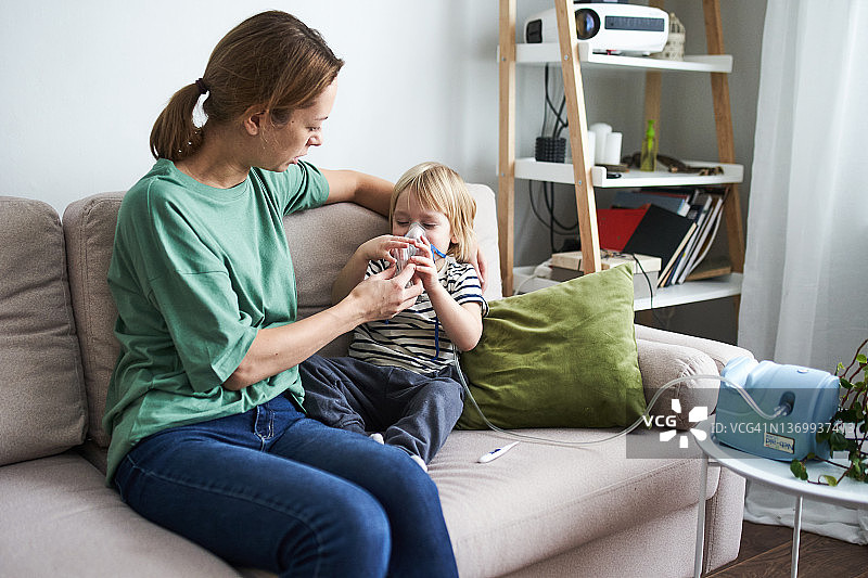 年轻母亲给孩子做雾化图片素材