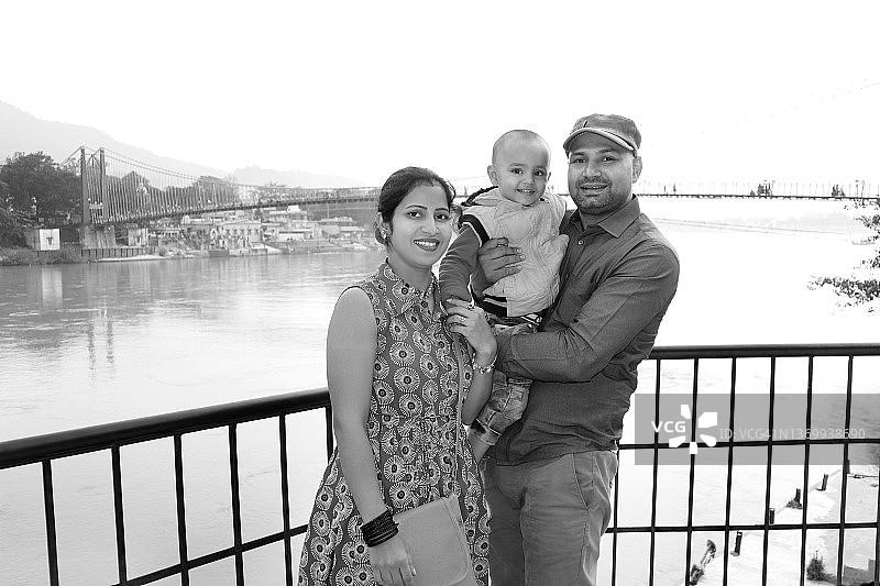 印度家庭站在瑞诗凯诗拉姆·朱拉桥附近，北阿坎德邦，印度图片素材