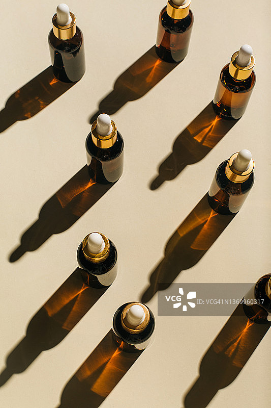 滴管化妆品玻璃瓶，米色背景天然护肤精油图片素材