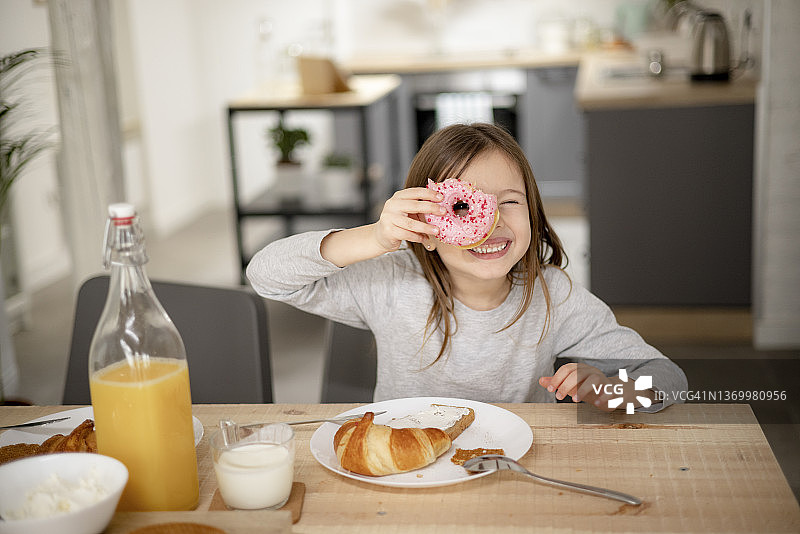 快乐的白人女孩在家享用糕点甜点的肖像图片素材