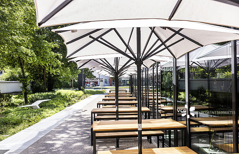 时尚餐厅白色遮阳伞下的户外空桌图片素材
