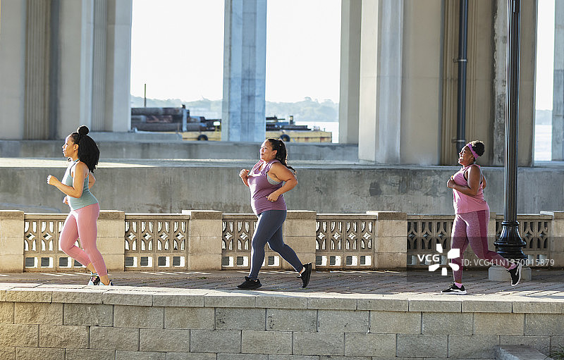 三名多种族女性在城市滨水区跑步图片素材
