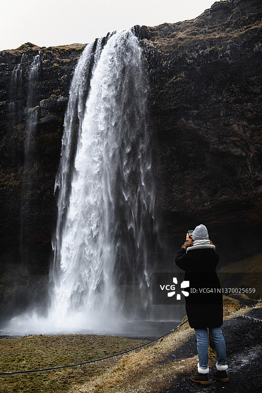 女人用智能手机拍照图片素材