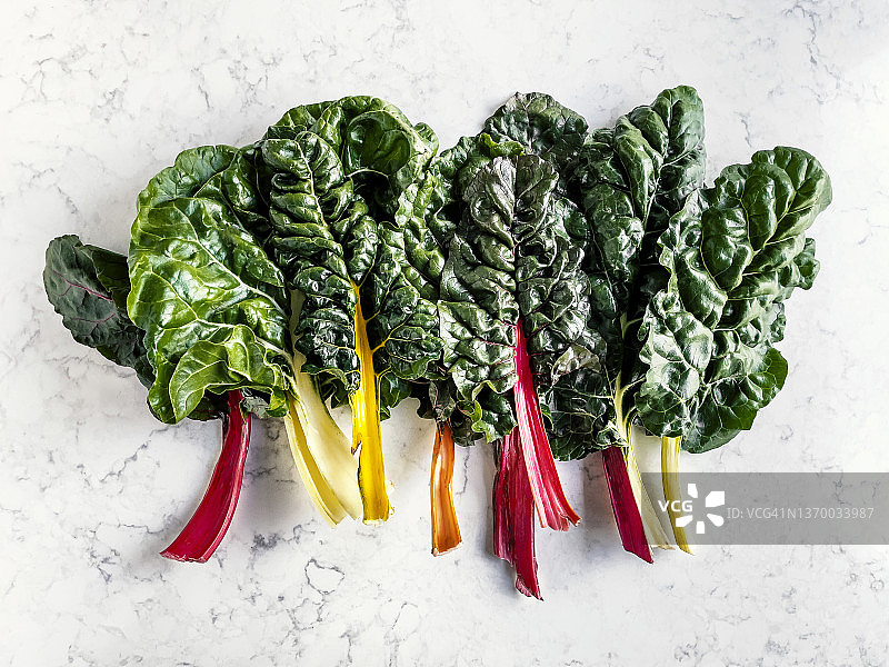 白色大理石背景上的瑞士甜菜叶图片素材