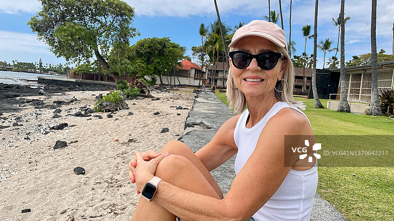 年长的女人坐在海堤上图片素材