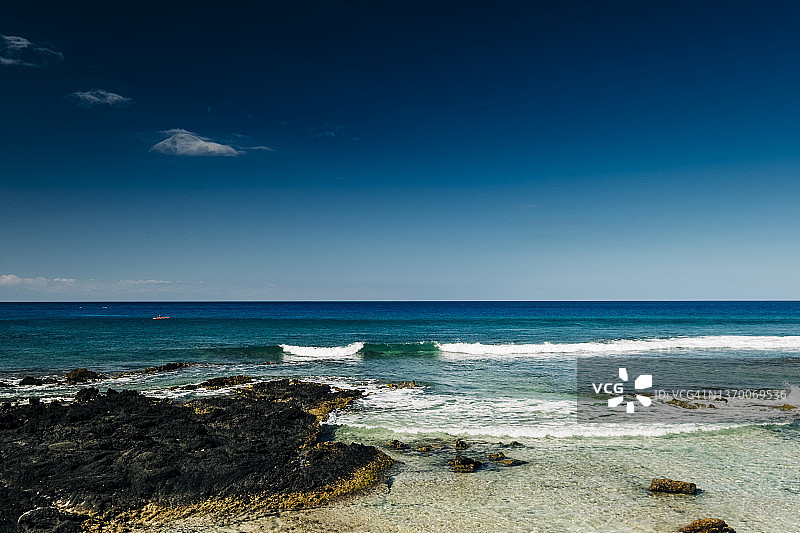 一位海上皮划艇运动员沿着夏威夷大岛的热带海岸线划桨图片素材
