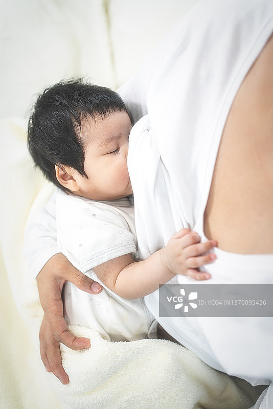 母亲在床上给新生婴儿喂奶图片素材