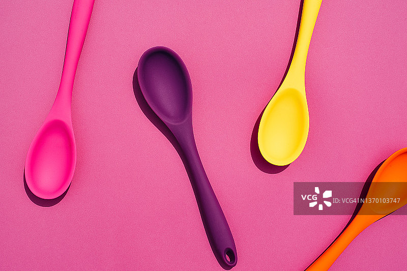 粉色背景上的彩色硅胶勺图片素材