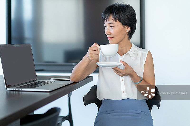 在办公室喝咖啡的白领女性图片素材