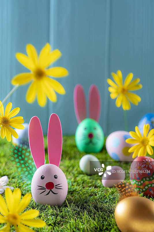 草地花园中的复活节彩蛋和春季雏菊花朵图片素材