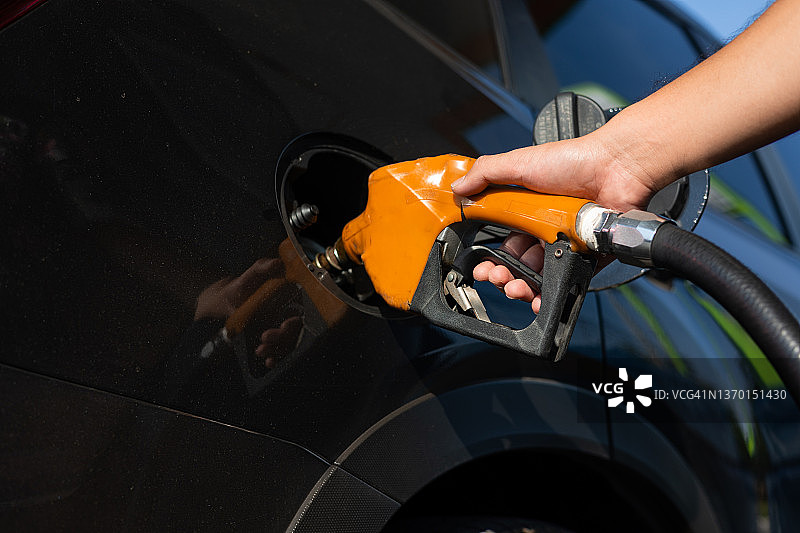 男子在汽车中手持燃油喷嘴图片素材