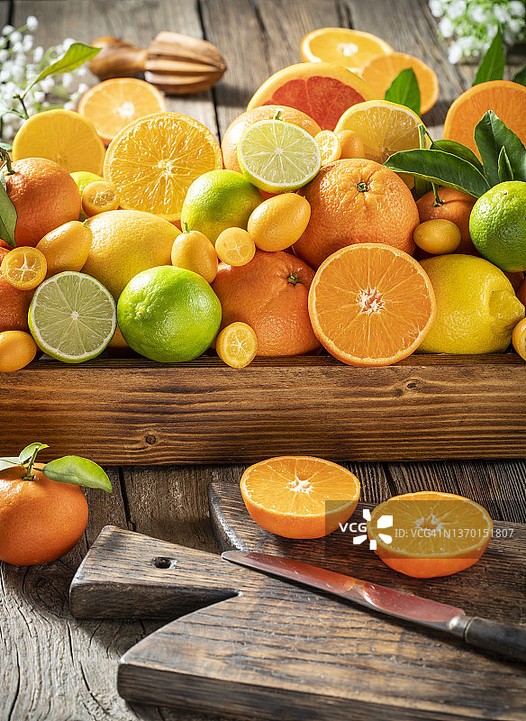 木质桌面背景上的新鲜采摘的混合柑橘类水果图片素材