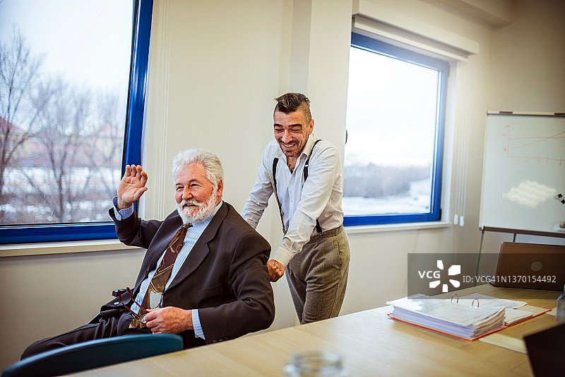 商务人士在办公桌前交流，同事在办公室开会讨论图片素材