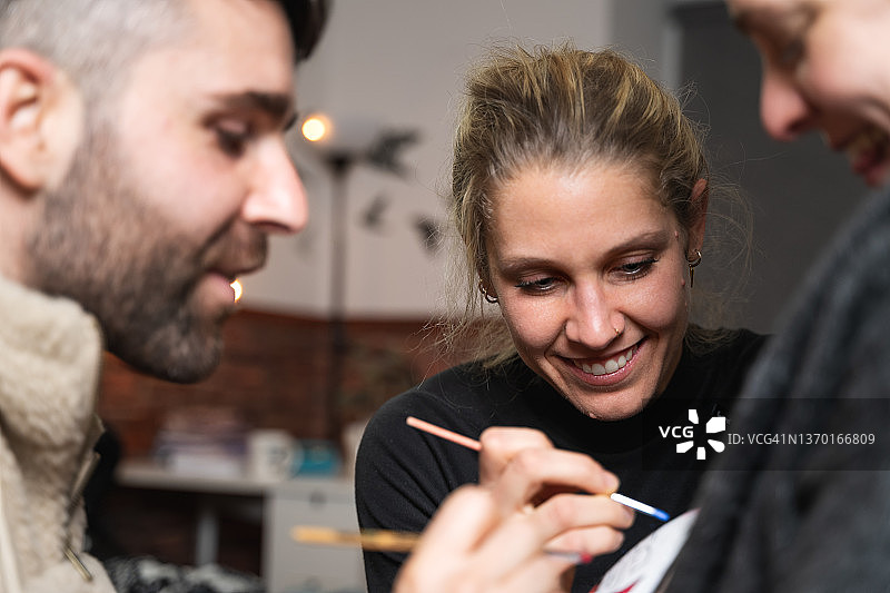 一起在孕妇肚子上绘画的快乐艺术家图片素材