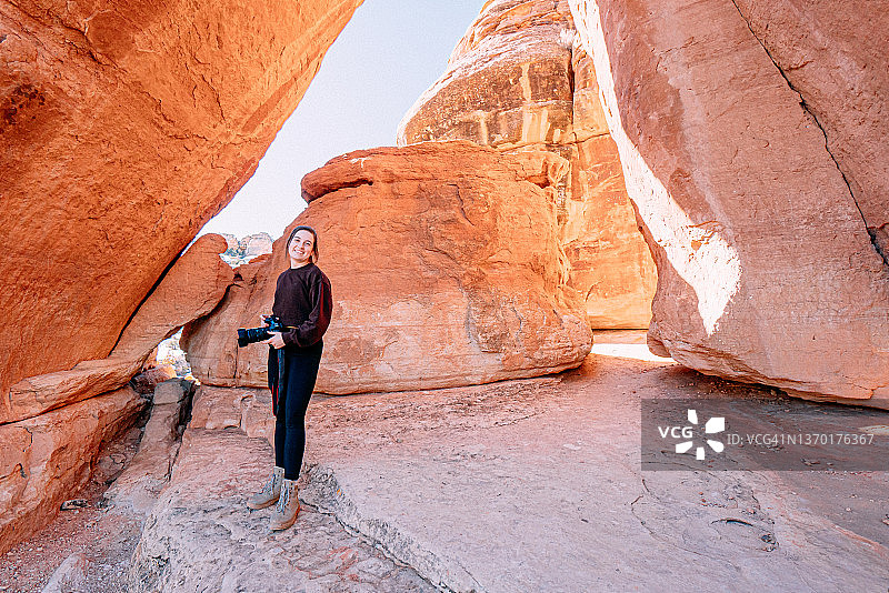 年轻女企业家在科罗拉多国家纪念碑参观和徒步旅行时手持专业单反相机户外拍摄的广角肖像图片素材