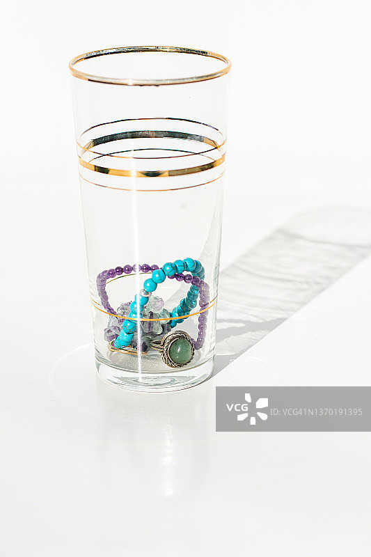 白色背景水晶玻璃杯中的各种珠子图片素材