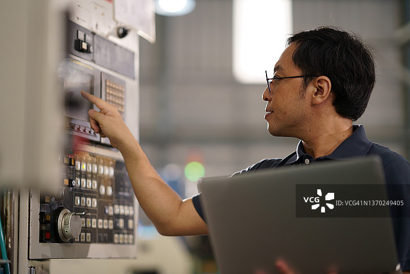 日本工业维修技术员检查工厂的机械控制面板图片素材