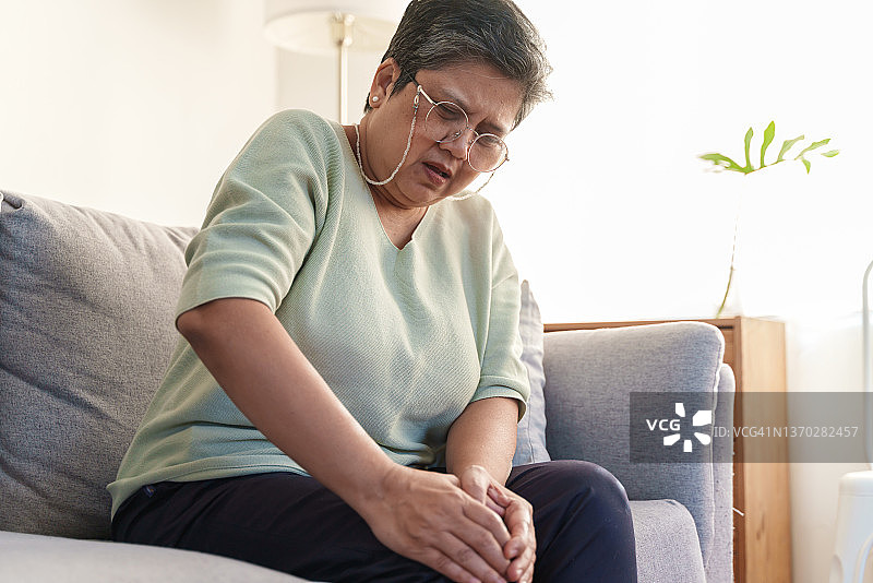 膝盖疼痛的年长亚洲妇女图片素材