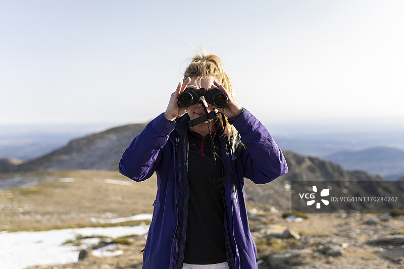 女背包客用双筒望远镜观赏风景和野生动物图片素材
