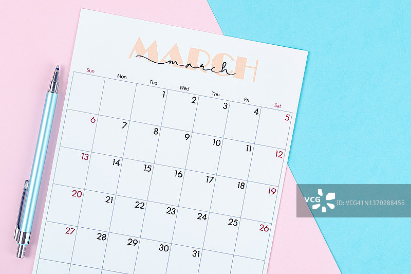 俯视：3月份日历，组织者在双色纸上用笔计划和书写图片素材