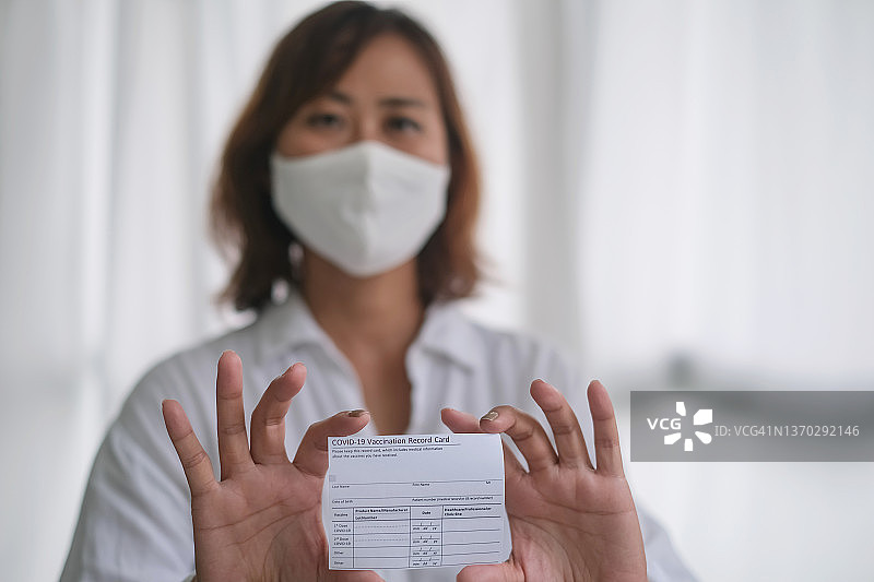 出示疫苗接种卡的亚洲中年妇女图片素材