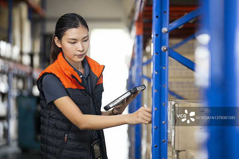 仓库主管使用触摸板监控库存平衡并更新ERP软件数据图片素材