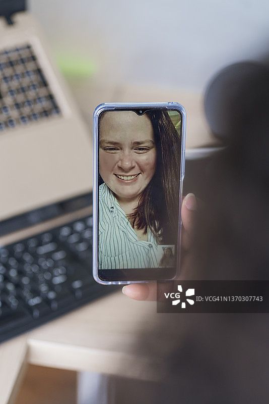 商务女性通过手机与客户进行视频通话图片素材