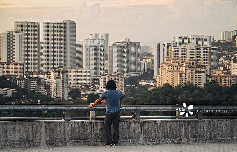 男子站在高速公路上看城市景观图片素材
