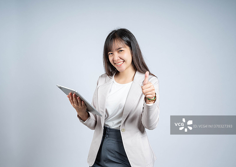 女人使用平板电脑并竖起大拇指图片素材