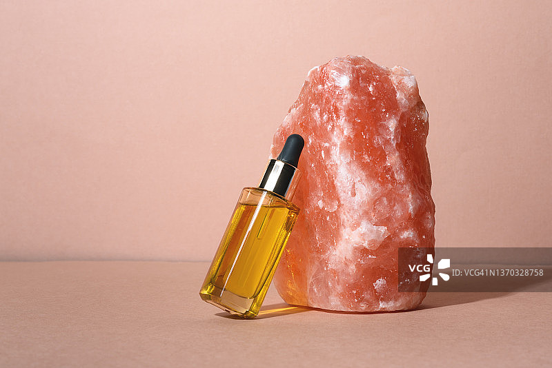 米色背景下的化妆品瓶和矿物盐图片素材