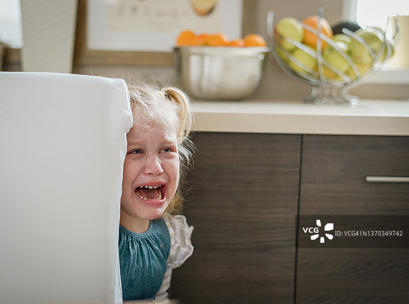 哭泣的金发女婴在家居室内图片素材
