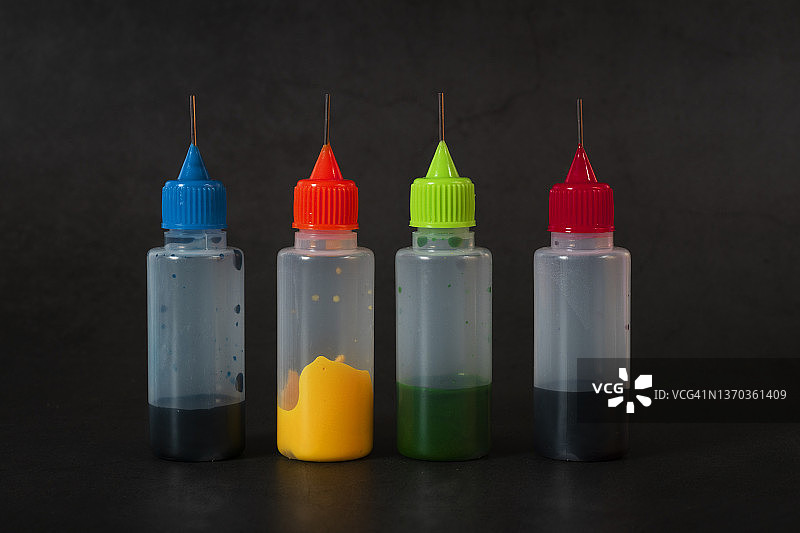 深色背景下的四瓶食用色素图片素材