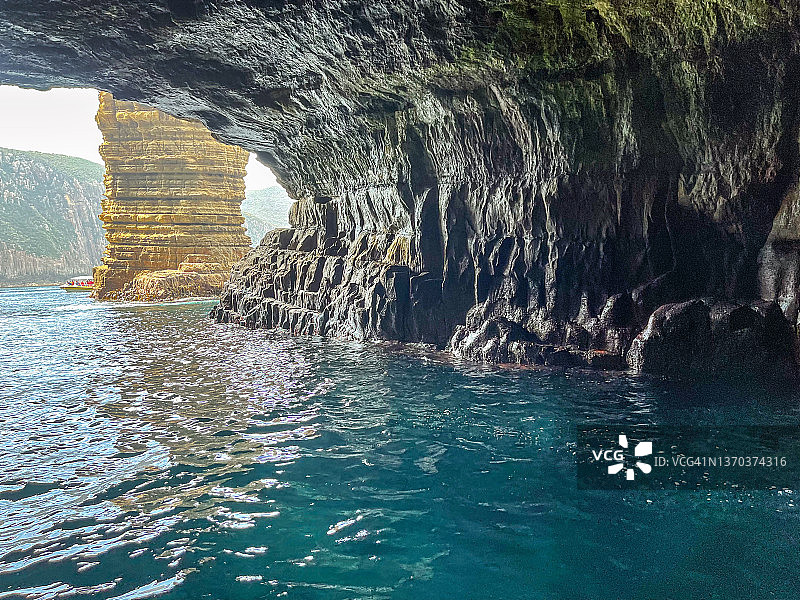 海蚀洞内部：外部岩层和碧绿的海水图片素材
