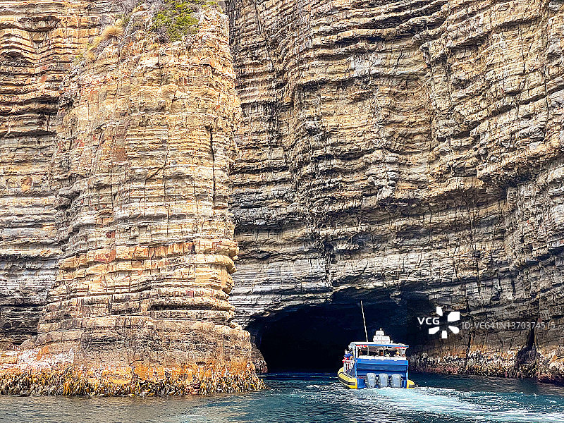游船驶入海蚀洞，岩石海崖，岩层，澳大利亚塔斯马尼亚图片素材