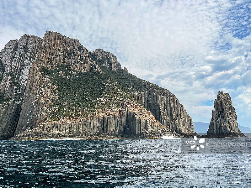 高耸海崖、山脉、海浪和岩层构成的岩石海岸线图片素材