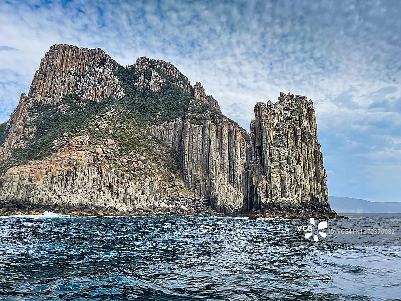 高耸海崖、山脉、海浪和岩层构成的岩石海岸线图片素材