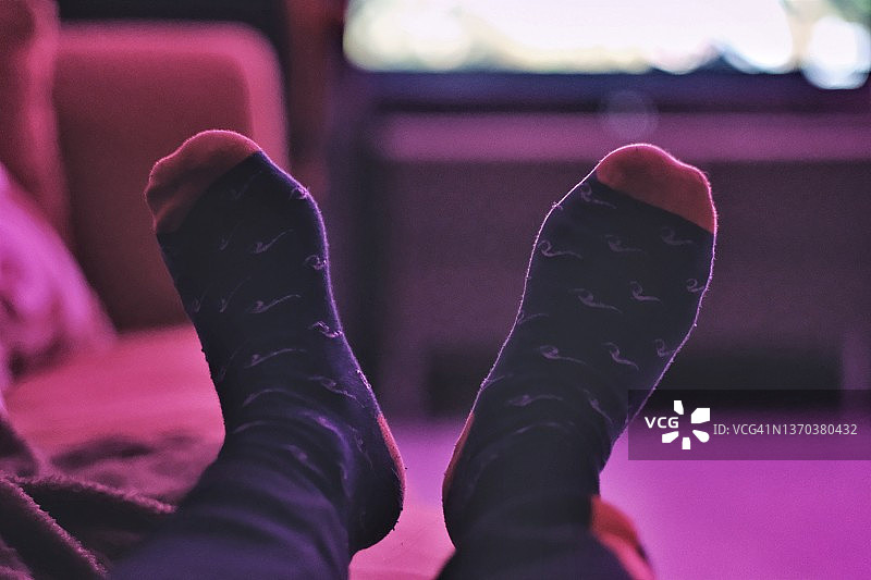床上穿着黑色袜子的双脚图片素材
